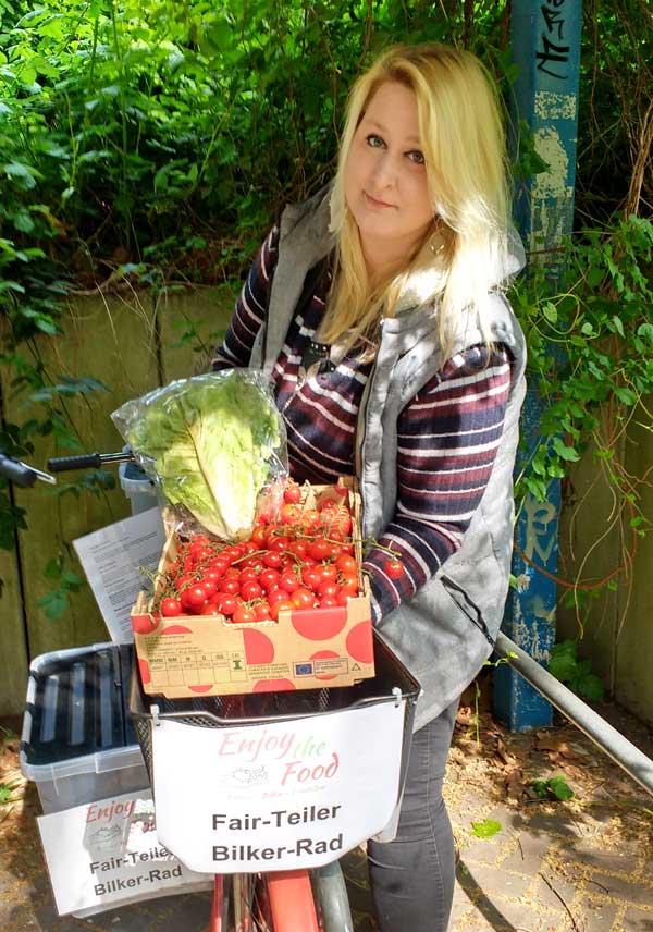 Eine Frau steht an einem Foodsharing-Fahrrad