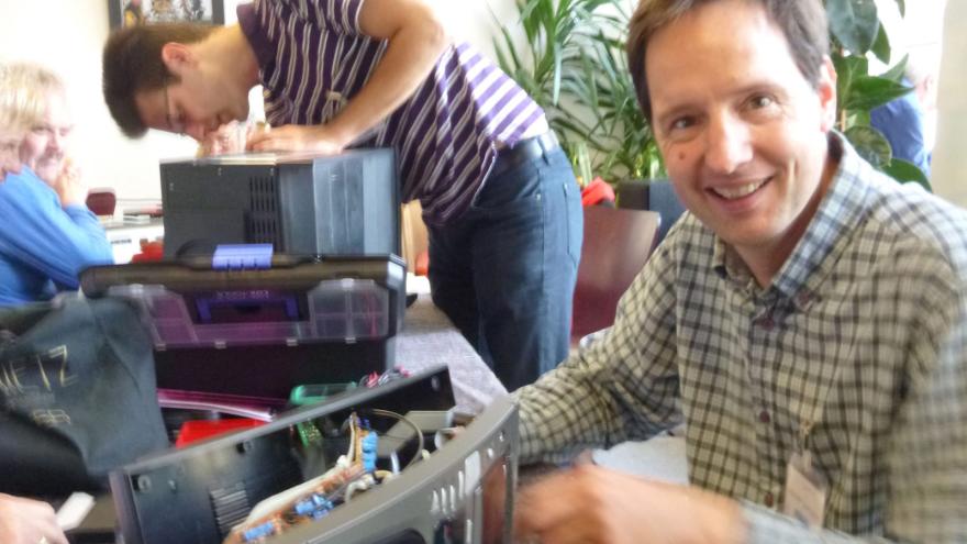 Ein Mann repariert ein elektronisches Gerät.