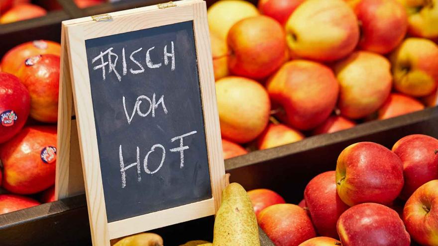 Eine Warenauslage mit Äpfel und Birnen und einem Hinweisschild "Frisch vom Hof"