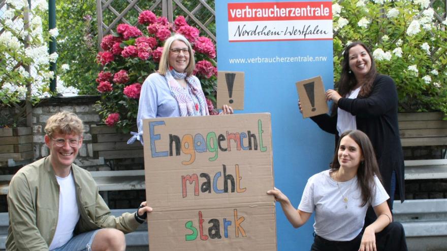 Gruppenfoto: Vier Personen mit einem Plakat "Engagement macht stark"