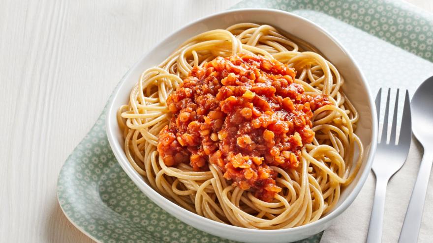 Vollkornspaghetti mit vegetarischer Linsensoße auf tiefem Teller