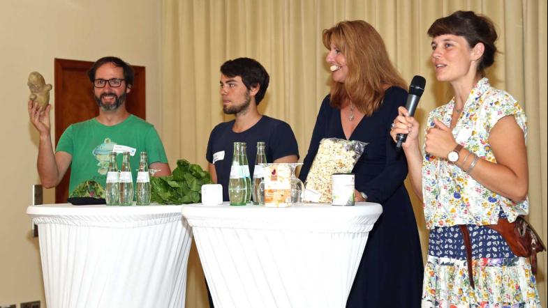 Initiativenvertreterinnen und Vertreter auf der Tagungsbühne im Gespräch.
