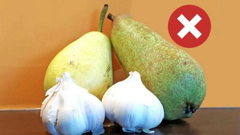 Birnen liegen neben Knoblauch.