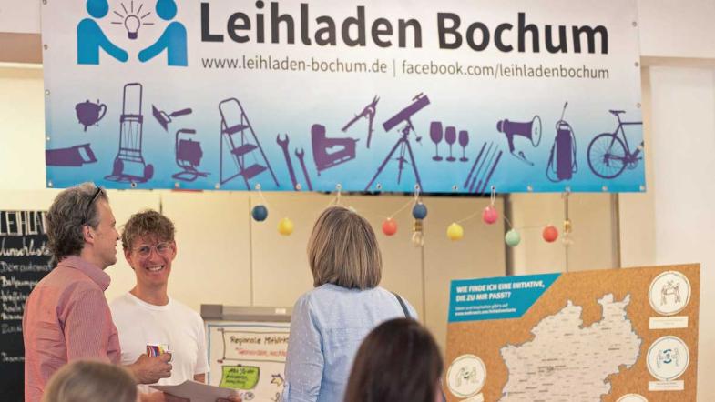 Mehrere Personen, über ihnen ein Banner "Leihladen Bochum"