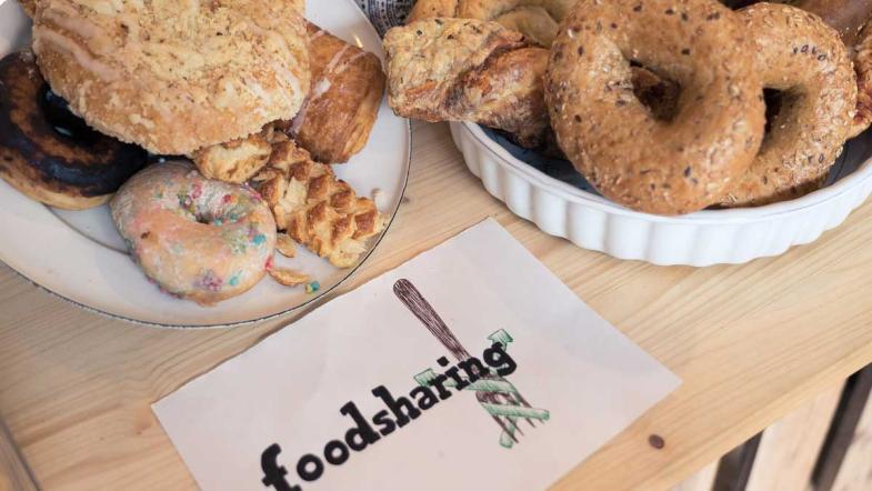 Brötchen und Gebäck, daneben ein Schild Foodsharing