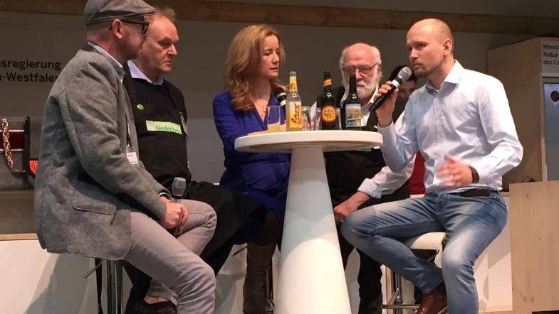 Mehrere Personen im Gespräch auf einer Bühne