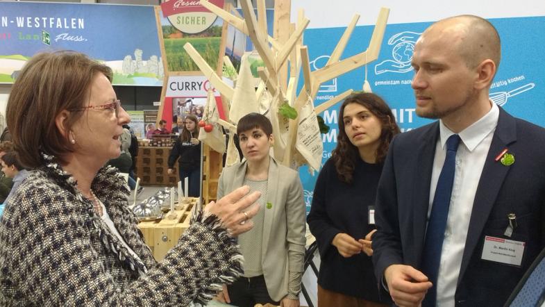 Mehrere Personen unterhalten sich an einem Messestand