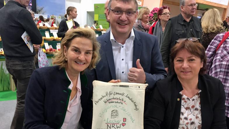 Zwei Frauen und ein Mann schauen in die Kamera