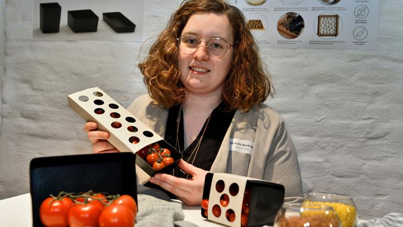 Eine Frau zeigt Verkaufsverpackungen für Tomaten