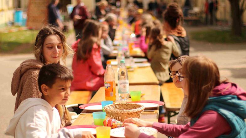 Kinder sitzen an Biertischen