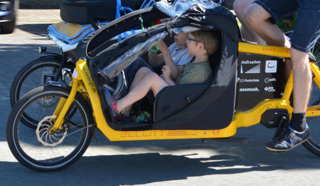 Zwei Kinder sitzen in einem Lastenrad.
