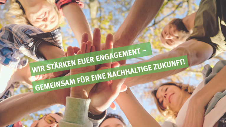 Mehrere Personen halten ihre Hände übereinander. Darüber ist der Schriftzug "Wir stärken euer Engagement - Gemeinsam für eine nachhaltige Zukunft!" zu lesen